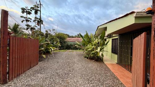 a driveway leading to a house with a red fence at Casa Pentagonia in Puerto Jiménez