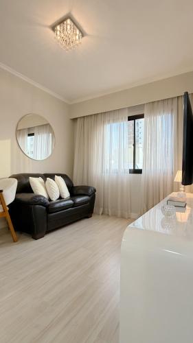 a living room with a black couch and a table at Ibirapuera Privilege - Suíte Deluxe Moema in São Paulo
