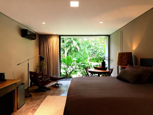 a bedroom with a bed and a large sliding glass door at Exclusive Oásis by Lotta De Macedo Soares in Petrópolis