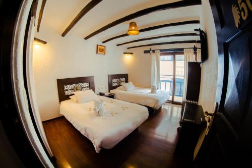 a hotel room with two beds and a window at Colpapampa Lodge in Colcapampa
