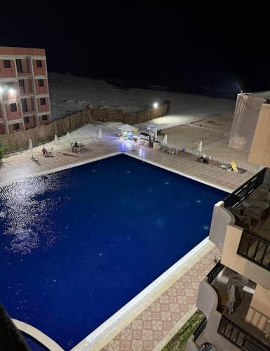 a large blue swimming pool at night at Asala Village, Blue Bay Resort, Marsa Matrouh in Marsa Matruh