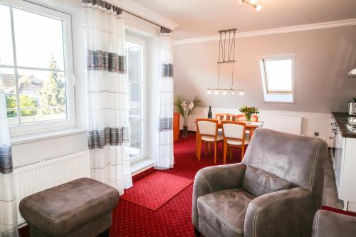a living room with a chair and a table at 3C-Appartements in Scharbeutz