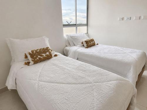 ein Schlafzimmer mit zwei Betten und einem Fenster in der Unterkunft Apartamento nuevo en Cartagena, Serena del Mar - INAWA in Cartagena de Indias
