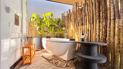 a bathroom with a toilet and a wooden fence at Villa Container SBO Refúgio Urbano com piscina e jacuzzi in Santa Bárbara dʼOeste