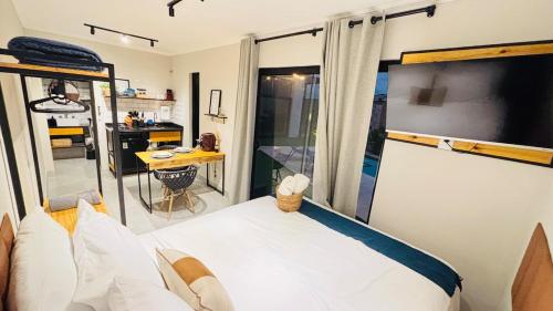 a small bedroom with a bed and a kitchen at Villa Container SBO Refúgio Urbano com piscina e jacuzzi in Santa Bárbara dʼOeste