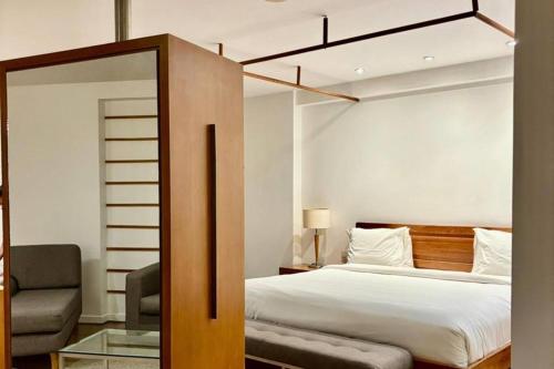 ein Schlafzimmer mit einem Bett und einem Stuhl in der Unterkunft Wyndham Macae in Macaé