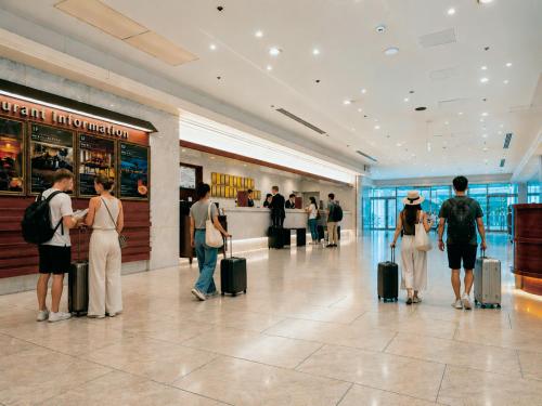a group of people standing in a mall with luggage at Hotel Plaza Osaka in Osaka