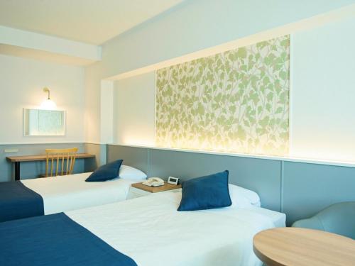a hotel room with two beds and a table at Hotel Plaza Osaka in Osaka