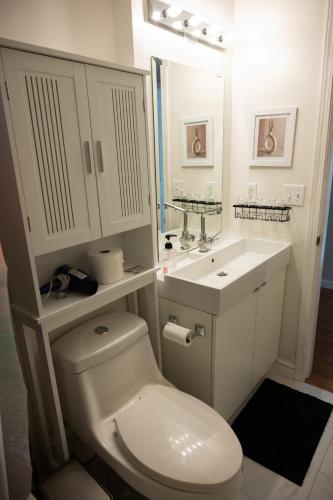 a white bathroom with a toilet and a sink at Cheng Rental in Surrey