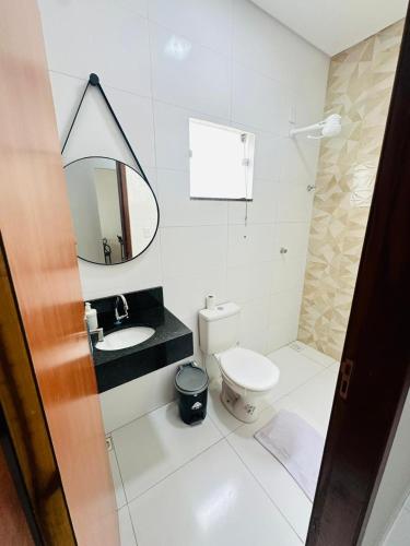 a bathroom with a toilet and a sink and a mirror at Casa da Gi em Piranhas in Piranhas