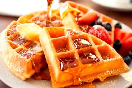 Baymont by Wyndham Kennesaw في كينيساو: طبق من الوافل مع الشراب والفواكه عليه