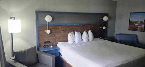 a hotel room with a bed and a chair at AmericInn by Wyndham Lincoln North in Lincoln