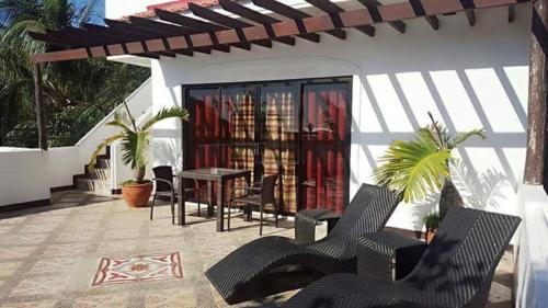 a patio with chairs and a table and a building at Sulu Sea Boutique Hotel in Boracay