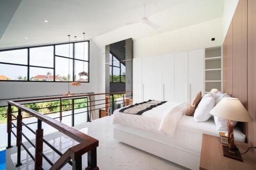 a bedroom with a bed and a balcony at Villa Effata close to Black Sand Beach in Keramas