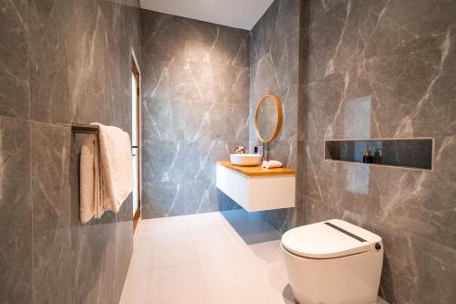 a bathroom with a toilet and a mirror at Villa Effata close to Black Sand Beach in Keramas
