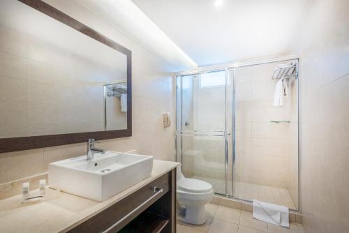 a bathroom with a sink and a shower and a toilet at Tryp by Wyndham Panama Centro in Panama City
