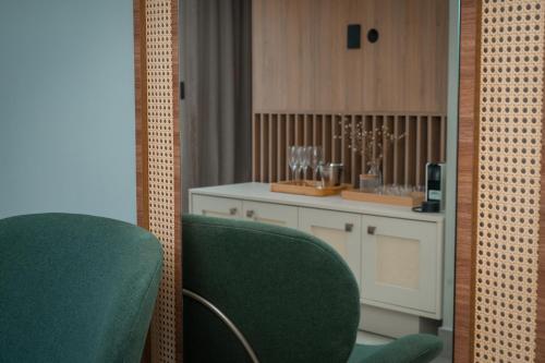 a room with two green chairs and a white counter at Be caju flats in Barra Grande