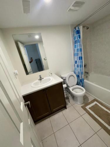 a bathroom with a sink and a toilet and a mirror at Comfort King in Oshawa