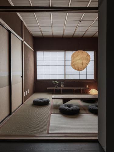 a room with pillows on the floor and a table at 一組限定の宿 季の間 Private Traditional House & Tea Experience in Nagano in Iida