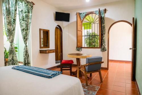 a bedroom with a bed and a table and a chair at Casa San Jerónimo in Puerto Escondido