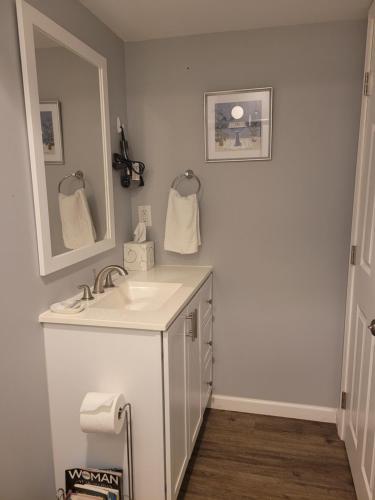 a white bathroom with a sink and a mirror at Blessings Private Home in Louisville