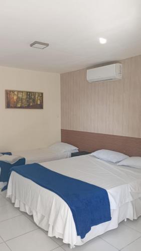 a bedroom with a large bed with a blue blanket at Pousada Recife Tropical in Recife