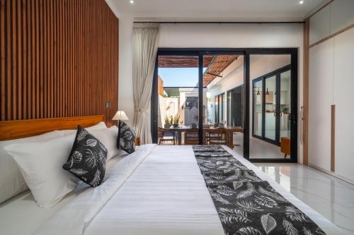 a bedroom with a large bed with black and white pillows at Villa Toograss close to Black Sand Beach in Keramas