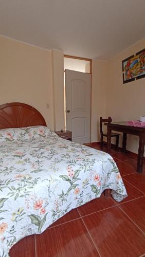 a bedroom with a bed with a floral comforter at La casa de Manuel in Lunahuaná