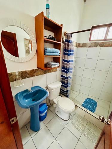 a bathroom with a blue sink and a toilet at PROMOCIOn VILLA PRIVADA SPRING in Puerto Ayora