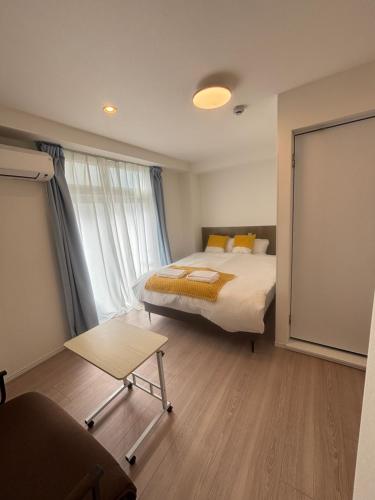 a bedroom with a bed and a large window at New Happy Smile-Self Check In in Tokyo