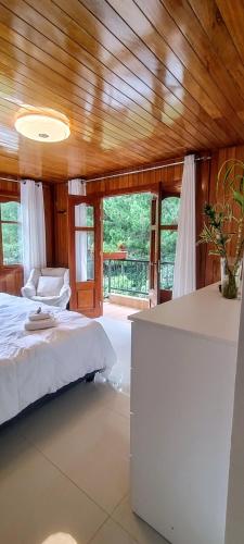 a bedroom with a bed and a couch and windows at Villa Amaranto Oxapampa in Oxapampa
