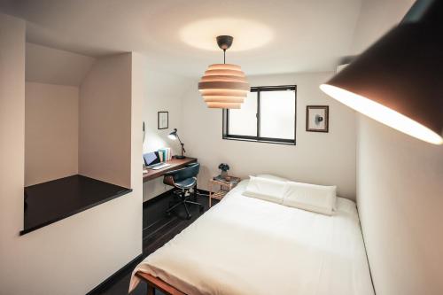 a small bedroom with a bed and a desk at こだま屋 in Tokyo