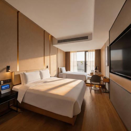 a hotel room with a large bed and a flat screen tv at Atour on the Bund in Shanghai