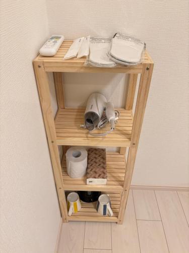 a small wooden shelf with items on it at New Happy Smile-Self Check In in Tokyo