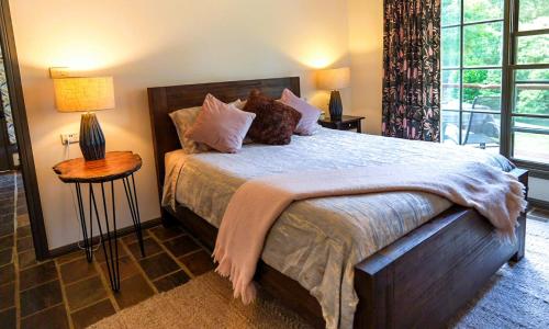 a bedroom with a large bed with pillows on it at The Bower at Wildside Sanctuary in Bilpin