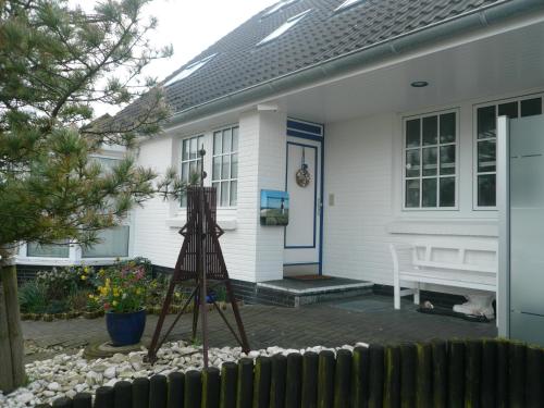une maison avec une structure en bois devant elle dans l'établissement "Haus am Deich", à Cuxhaven