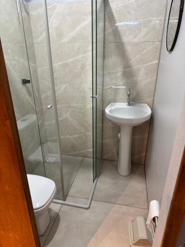 a bathroom with a shower and a toilet and a sink at Pousada Bonetti Quarto 11 in Santa Rosa