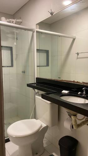 a bathroom with a toilet and a sink and a mirror at Pousada Recife Tropical in Recife