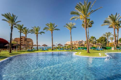a large pool with palm trees in a resort at Holiday World Resort, Affiliated by Melia in Benalmádena