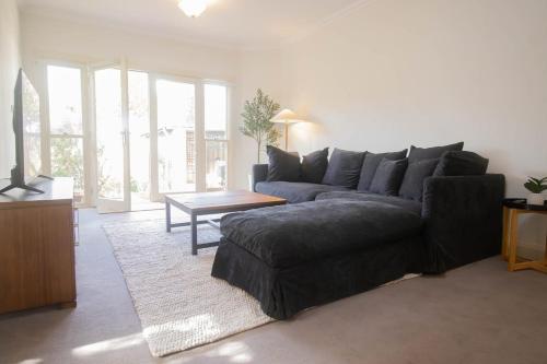 a living room with a couch and a table at Picket Fence On Ligar in Ballarat
