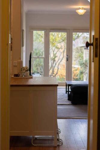 a kitchen with a counter and a living room at Picket Fence On Ligar in Ballarat