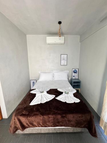a bedroom with a large bed with two white pillows at Pousada Bonetti Quarto 9 in Santa Rosa