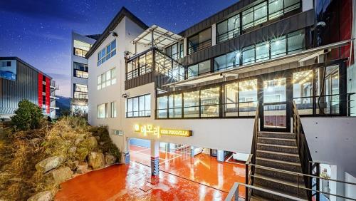 a large building with a staircase in front of it at Geoje Memory Kidspoolvilla in Geoje