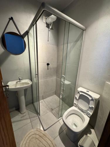 a bathroom with a shower and a toilet and a sink at Pousada Bonetti Quarto 8 in Santa Rosa