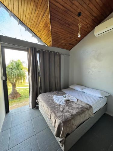a bedroom with a bed and a large window at Pousada Bonetti Quarto 8 in Santa Rosa