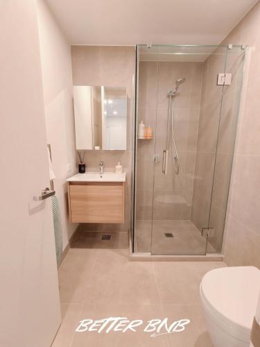 a bathroom with a shower and a sink and a toilet at Bloom Central – Pool & Gym in Wellington