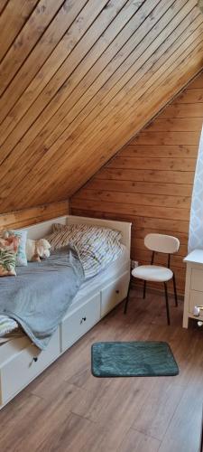 a bedroom with a bed and a wooden ceiling at Bacówka pod Ślężą in Sulistrowice