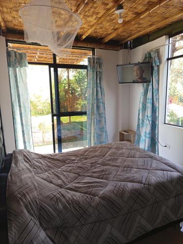 a bedroom with a bed and a tv on the wall at Casa Rústica Diaz in Ica