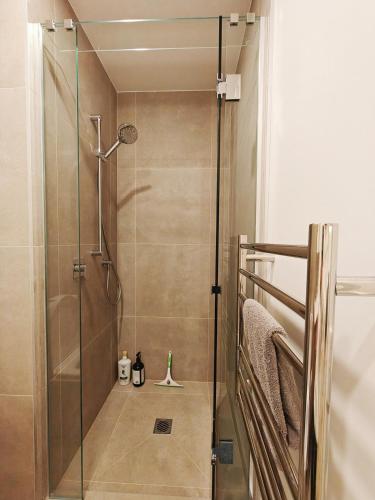 a shower with a glass door in a bathroom at The Urban Nest 613 in Wellington