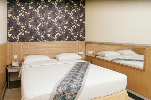 two beds in a room with a painting on the wall at Golden Gate Hotel in Bagam